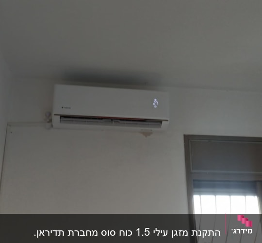 מזגן מותקן על קיר לבן עם תצוגת טמפרטורה